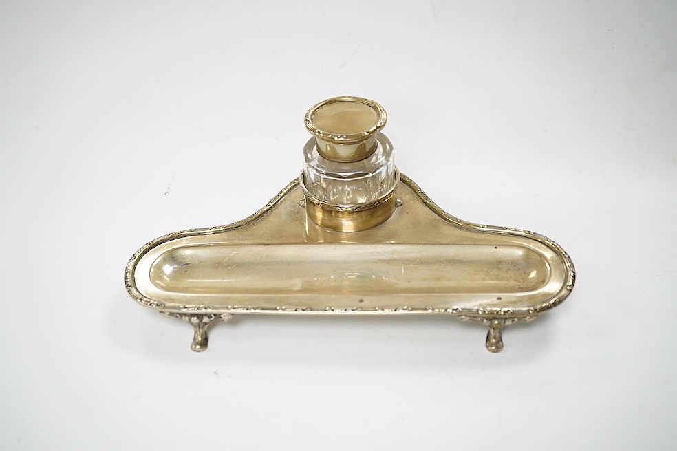 An Edwardian silver inkstand, with mounted glass well and pen recess, Hukin & Heath, Birmingham, 1905, 23cm. Condition - poor to fair